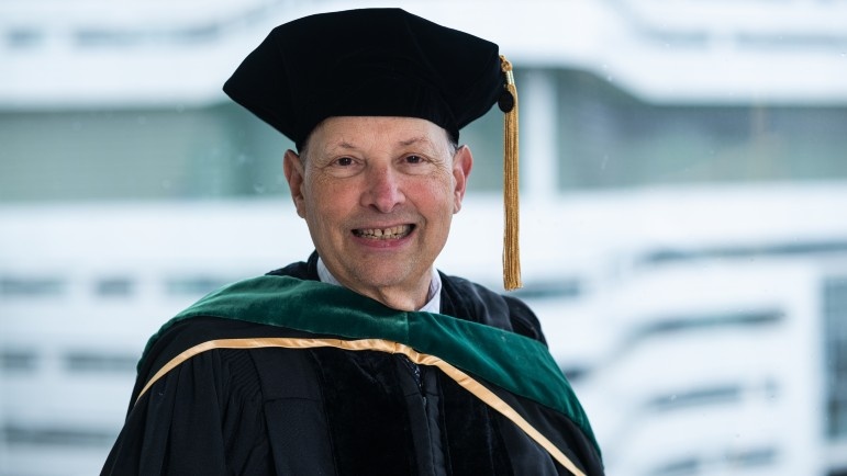 Robert Balk, MD, smiles in his regalia as university marshal.