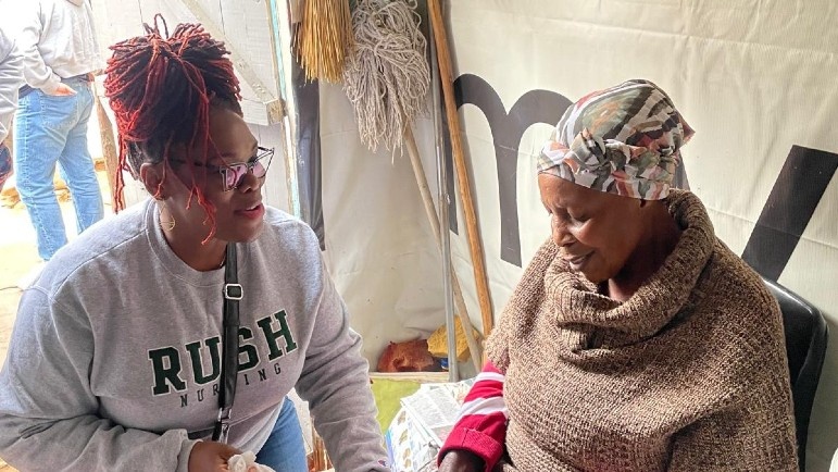 Aisha Ealey, DNP, APRN, cares for women and babies across the world. She is wearing a gray Rush University College of Nursing crewneck.
