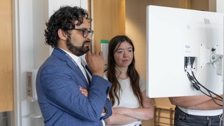 Arka Mallela, MD, MS, assistant professor, Department of Neurological Surgery, and Jackie Bollinger use the MindTrace system to assess a patient.
