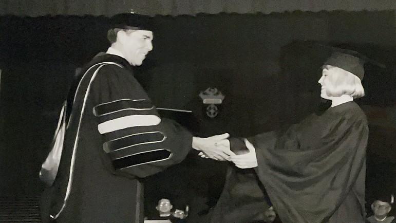 Archival photo of a graduate receiving a diploma